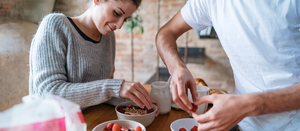 Egy nő és egy férfi antioxidánsokban gazdag reggelit készít az asztalnál.